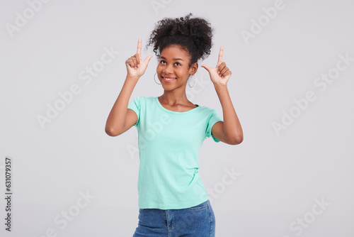 With posing panache, a woman wears mint shirt and blue jeans, showcasing her style and flair during the studio fashion shoot. © Duangporn