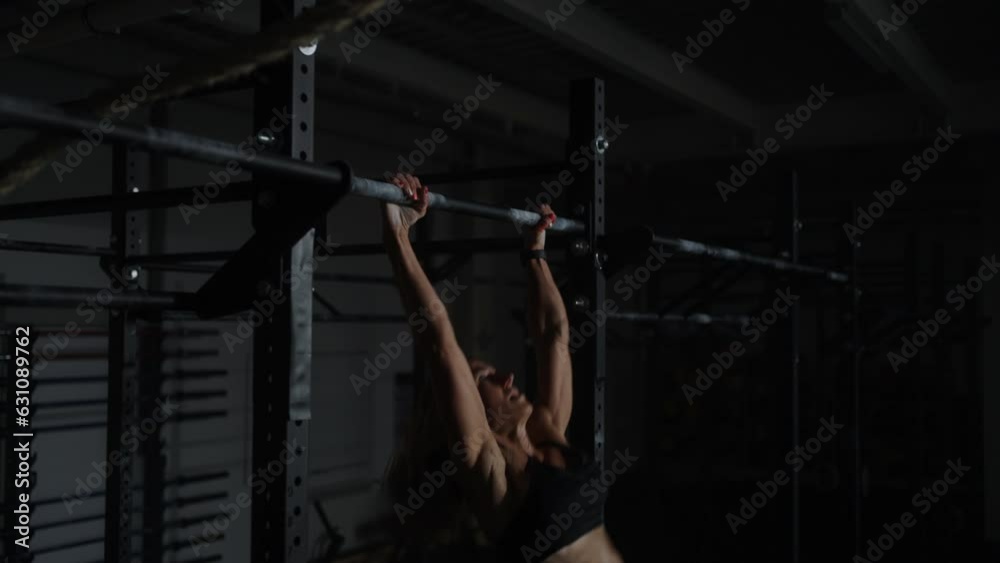 Professional Sportswoman With Muscular Slender Figure Doing Pull-Ups On Crossbar In Gym Professional Sportswoman With Muscular Slender Figure Doing Pull-Ups On Crossbar In Gym