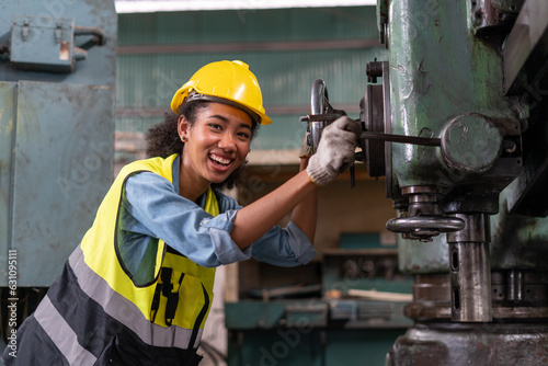happy african american engineer worker woman smiling and working with machine in factory . cheerful black female employee . positive emotion. feel good