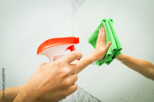 Wash mirror spray. woman cleans mirror in bathroom Housekeeping, cleaning service. Clean house