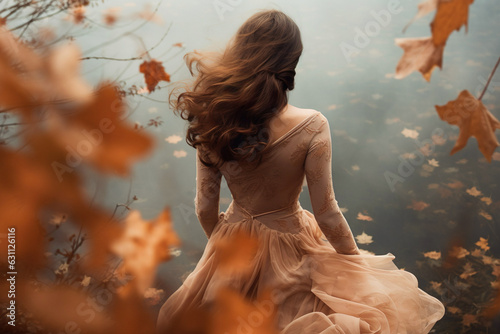 Dreamlike autumn scene with running woman and falling leaves. Romantic woman in long dress at a pond in fall.