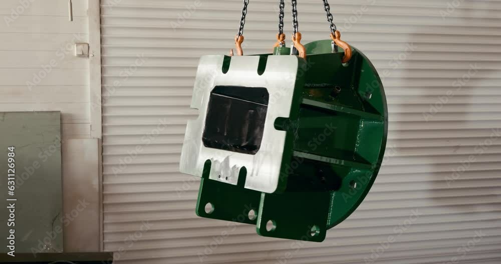 a large metal object hanging on a chain in a factory store