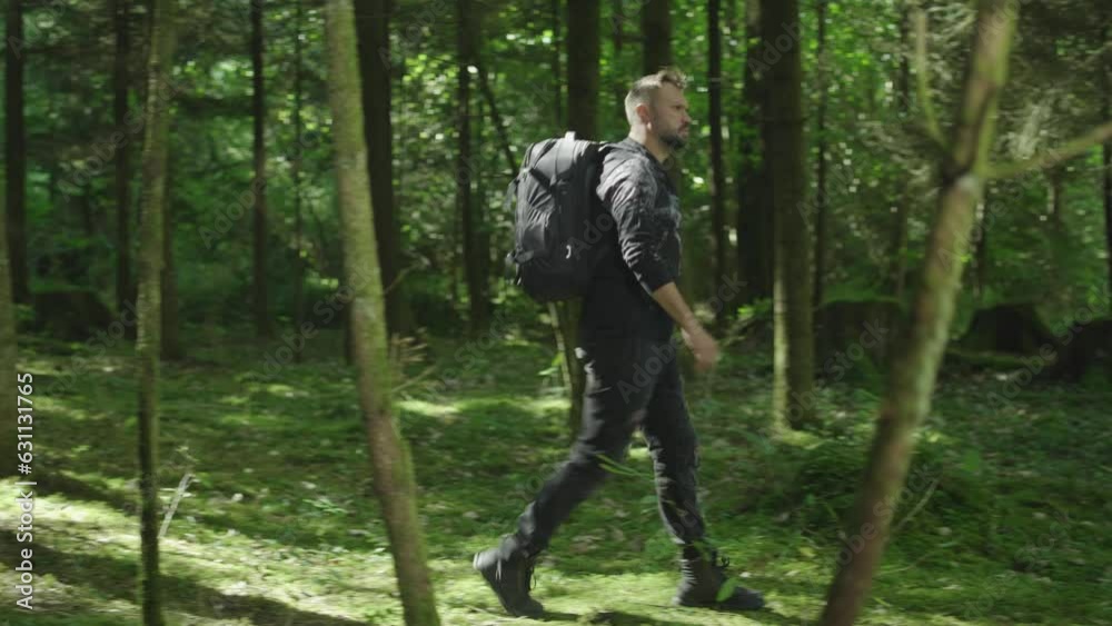 A person hiking or camping outdoors is walking along a trail. Outdoor lifestyle. The man got lost in the forest. green forest at high altitude. View of an active healthy man with a backpack on a walk. A person hiking or camping outdoors is walking along a trail. Outdoor lifestyle. The man got lost in the forest. green forest at high altitude. View of an active healthy man with a backpack on a walk.