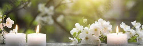 white flowering branch and 3 white candle lights outside in a garden  floral concept with burning candles decoration for contemplative athmosphere background