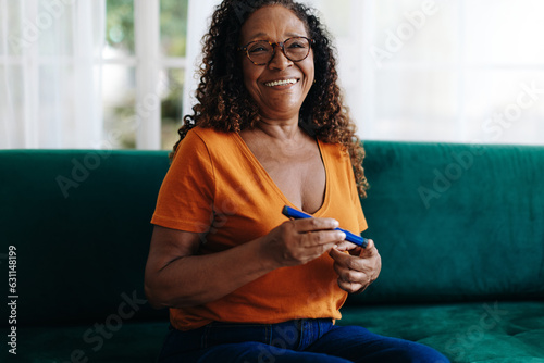 Happy senior woman controlling her blood glucose with an insulin delivery
