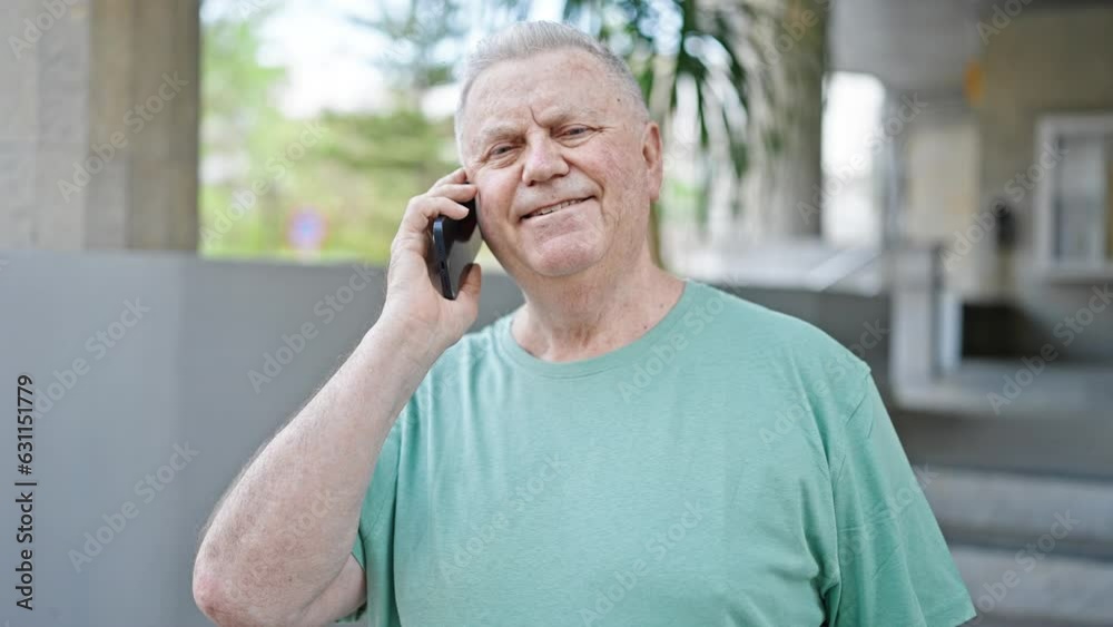 Middle age grey-haired man smiling confident talking on the smartphone at street Middle age grey-haired man smiling confident talking on the smartphone at street