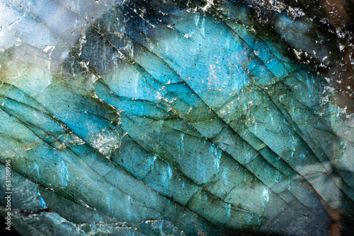 This is a colorful macro photo of a luminous and iridescent labradorite stone.  The patterns and otherworldly blue colors give it a science fiction landscape look. 