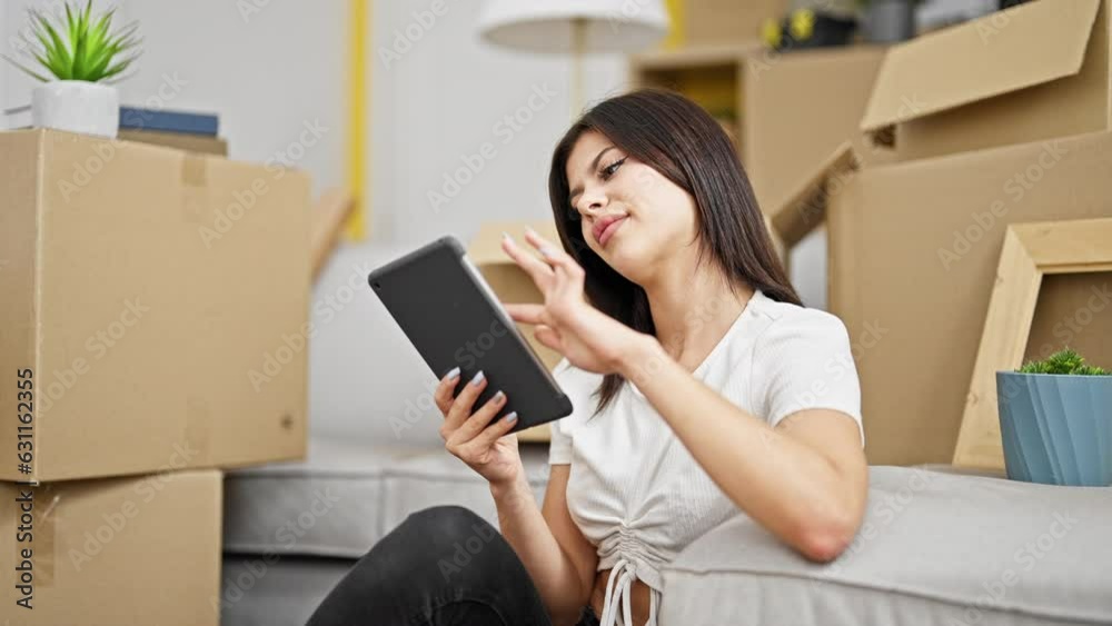 Young caucasian woman using touchpad sitting on floor at new home Young caucasian woman using touchpad sitting on floor at new home