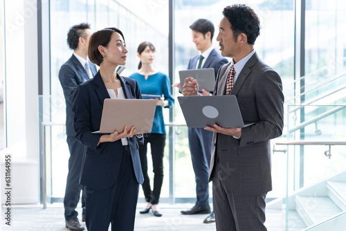 立ちながら会議をする複数のビジネスマン photo