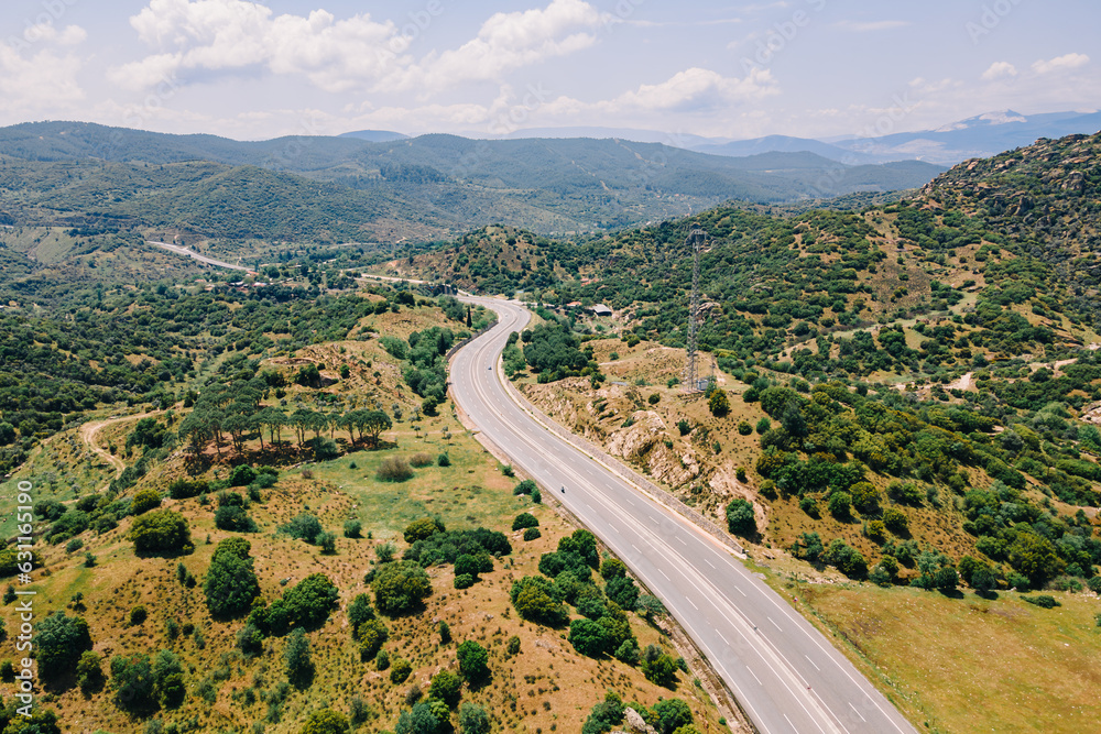 Aerial view of traffic highway through a green mountains