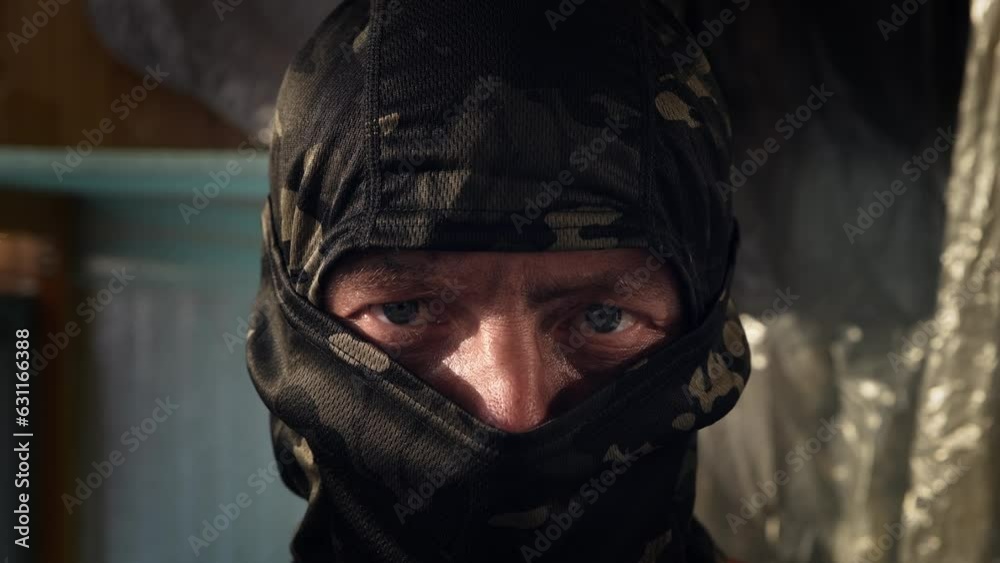 Man in a khaki fabric mask, balaclava. The concept of refusal and approval. The man shakes his head Man in a khaki fabric mask, balaclava. The concept of refusal and approval. The man shakes his head