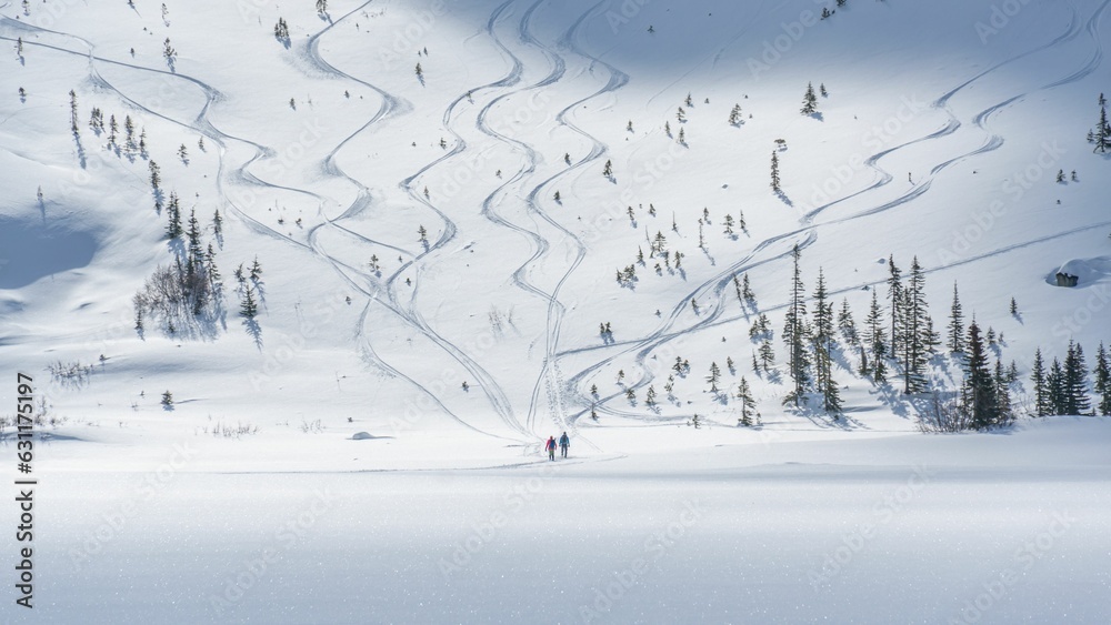 Vast expanse of a snow-covered field leading to the mountain with people climbing up
