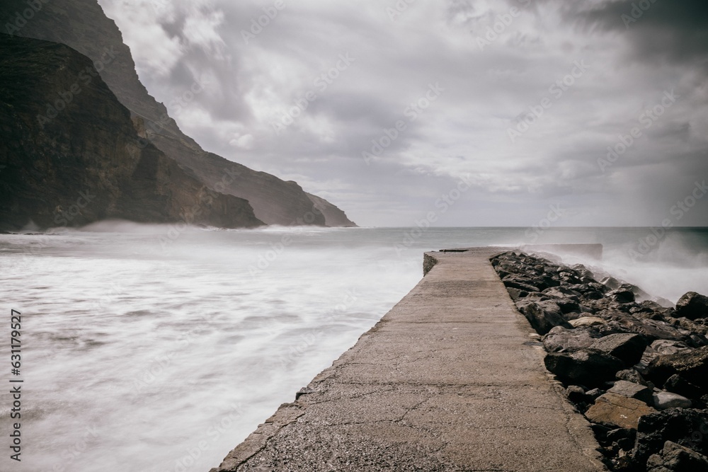 Scenic view of a pier jutting out into the ocean with dramatic cliffs La Gomera, Spain