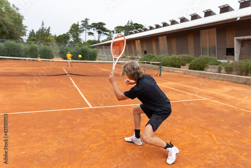 Two sportive boys playing friendly tennis match on the court © KONSTANTIN SHISHKIN