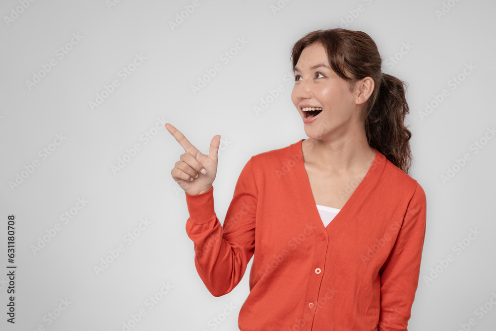 Portrait asian beautiful girl pointing blank space isolated background. Happy woman pointing on something. young female standing pointing finger sideways, billboard, introduction, advertisement, space