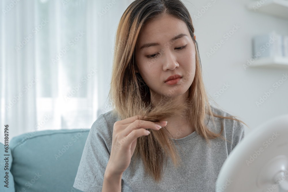 Asian woman very sad and upset looking at damaged hair, hair loss, hair thinning problem, vitamin deficiency, baldness, postpartum, biotin, zinc, menstrual or endocrine disorders, hormonal imbalance Asian woman very sad and upset looking at damaged hair, hair loss, hair thinning problem, vitamin deficiency, baldness, postpartum, biotin, zinc, menstrual or endocrine disorders, hormonal imbalance