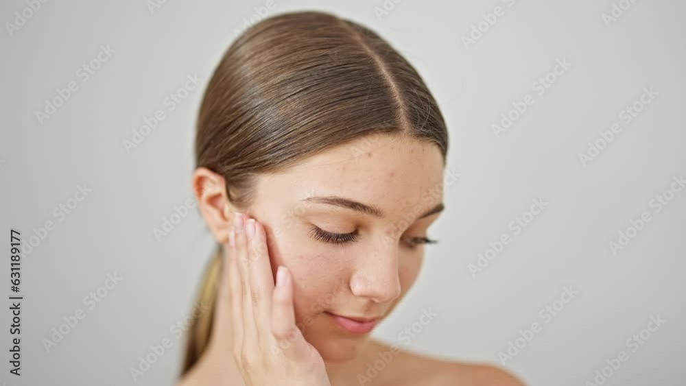 Young beautiful girl smiling confident massaging face over isolated white background Young beautiful girl smiling confident massaging face over isolated white background