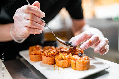 professional chef's hands making sushi roll in a restaurant kitchen