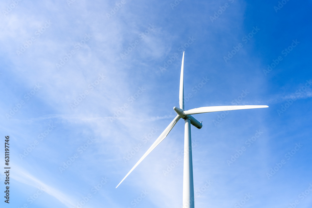 Detail of wind turbine against blue sky with clouds on a sunny autumn day Detail of wind turbine against blue sky with clouds on a sunny autumn day