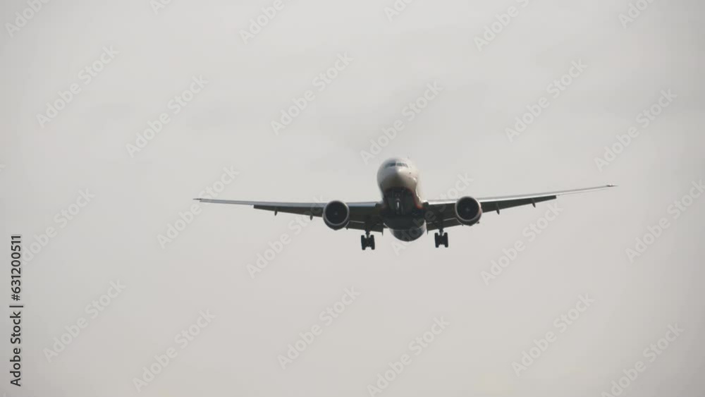 Wide body airliner descending overhead. Passenger airliner landing approach, long shot. Commercial carrier flying Wide body airliner descending overhead. Passenger airliner landing approach, long shot. Commercial carrier flying