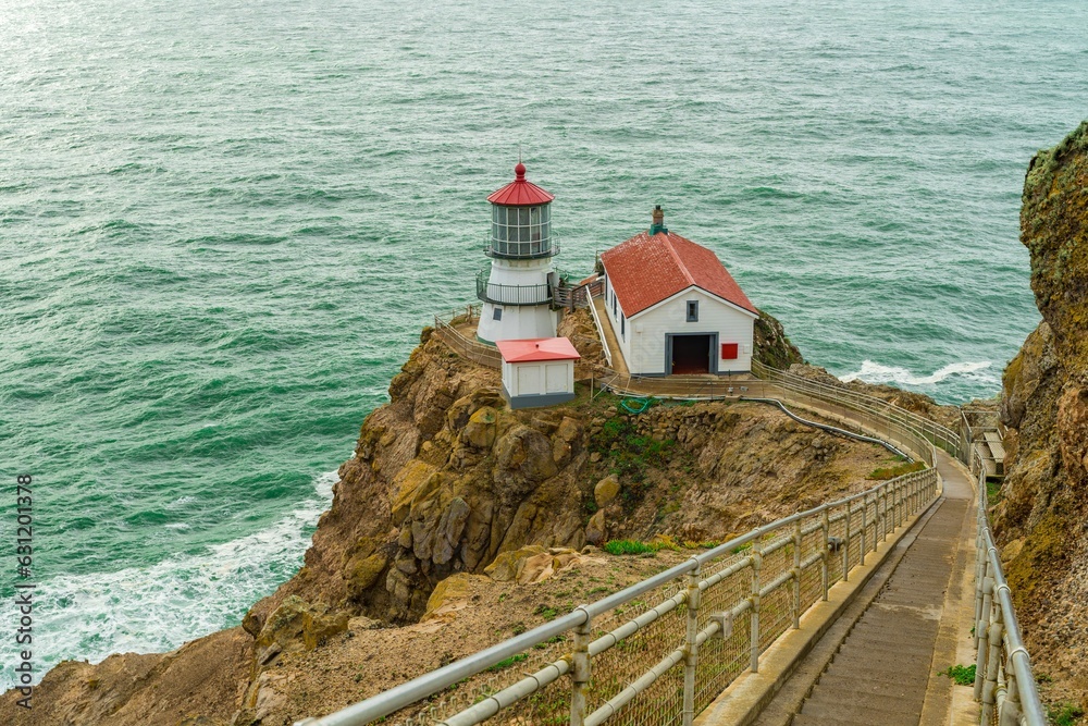 a lighthouse next to the ocean with steps leading to it a lighthouse next to the ocean with steps leading to it