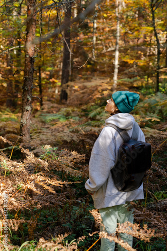 Woman traveler with backpack in autumn forest