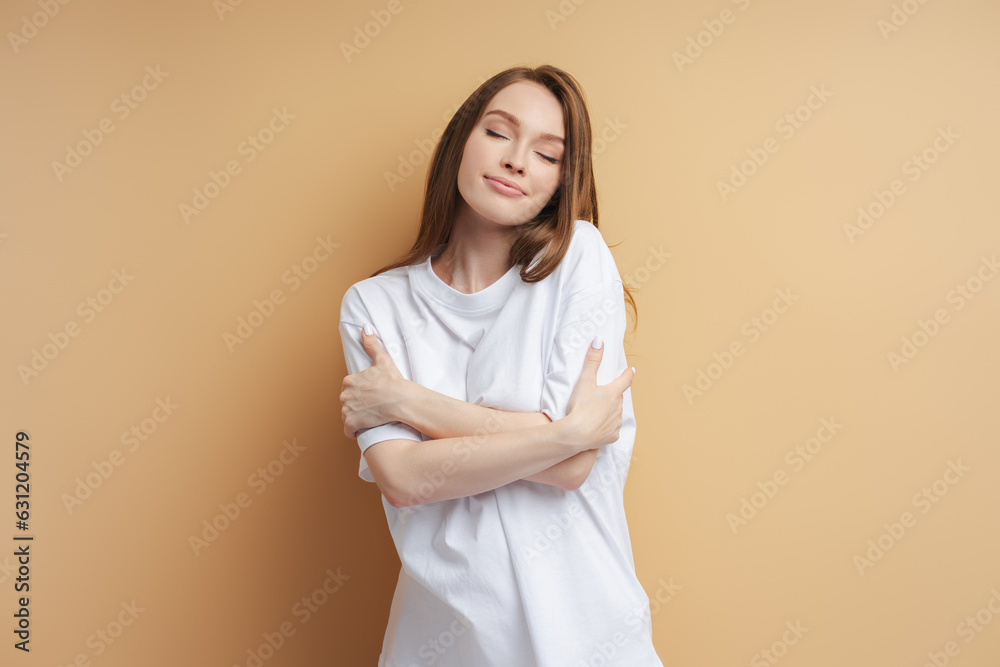 Portrait of cute woman hugging herself with closed eyes isolated Portrait of cute woman hugging herself with closed eyes isolated