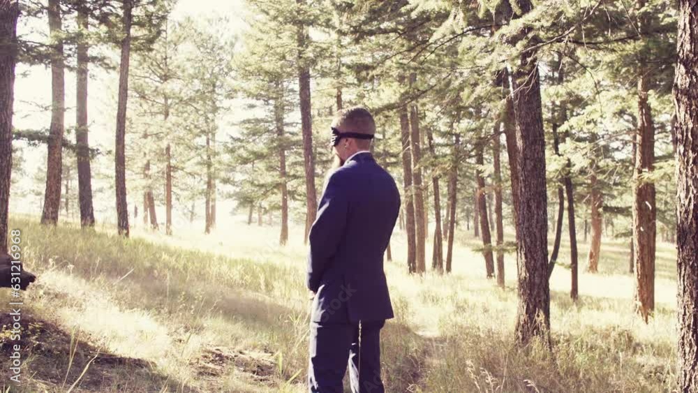 Caucasian groom standing with a blindfold in the garden Caucasian groom standing with a blindfold in the garden