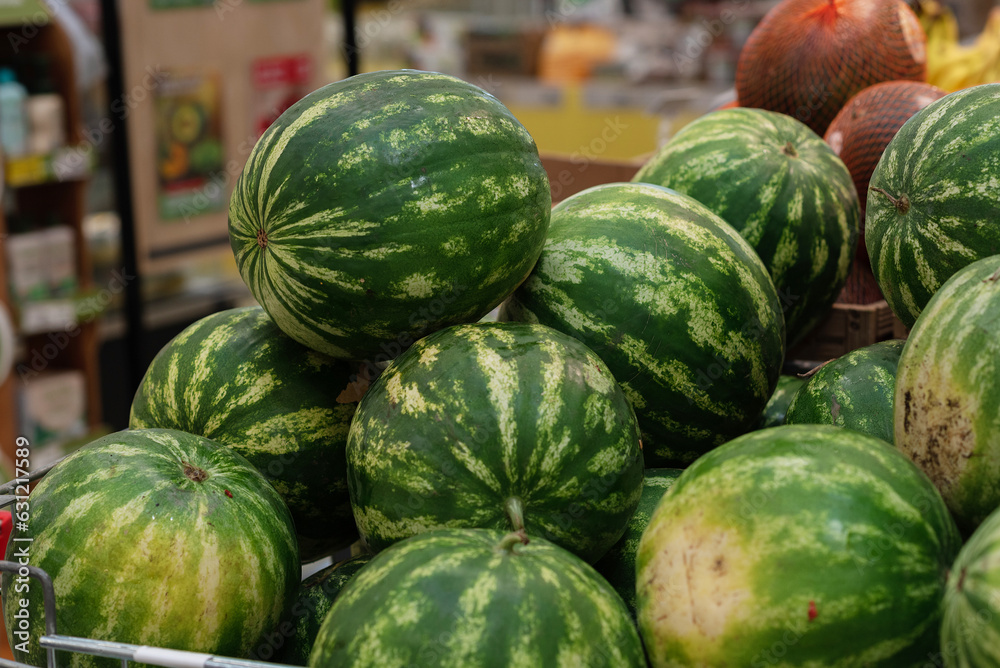 Watermelons on supermarket. Summer Fruits. Fresh organic water melon fruit for sale in grocery store. Healthy fruit