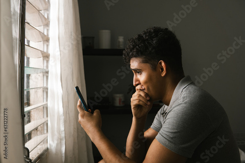 Foto Side portrait of man sadness looking a mobile phone.