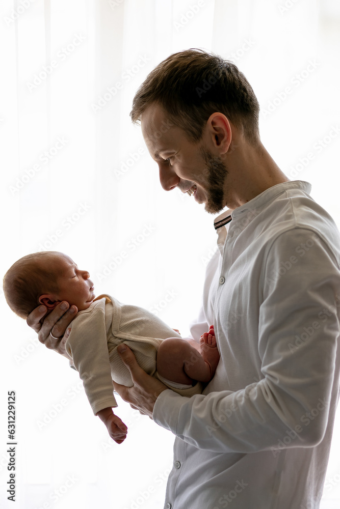 Happy father holding sleeping infant child on hands. Father hugging her little one months old son. Authentic lifestyle real life touching tender moment. Happy father holding sleeping infant child on hands. Father hugging her little one months old son. Authentic lifestyle real life touching tender moment.