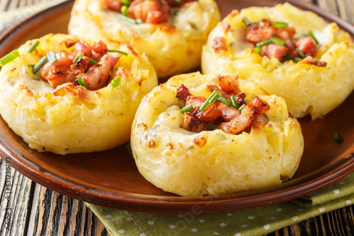 Stuffed Mashed Potato Nests Filled With Bacon And Onion close-up in a plate on the table. Horizontal