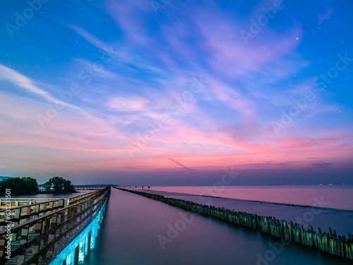 Sea view near mangrove forest with man made wooden barrier for wave protection  under morning twilight colorful sky in Bangkok  Thailand