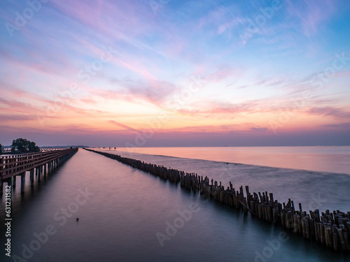 Sea view near mangrove forest with man made wooden barrier for wave protection  under morning twilight colorful sky in Bangkok  Thailand