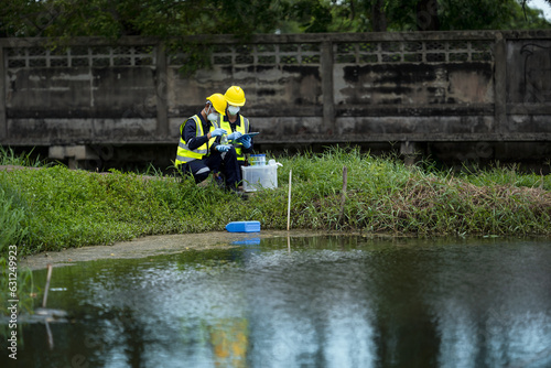 Billede på lærred Environmental researchers investigate the condition of canal water for toxic spills, river waste water sampling, Asian researchers collect water samples in farmland for research and development