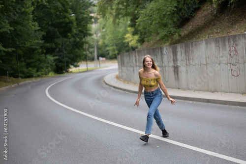 Wallpaper Mural A young beautiful girl is jumping on a bend in the road Torontodigital.ca