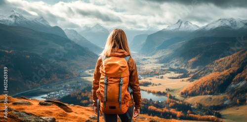 a young woman with backpack is standing on top of a mountain