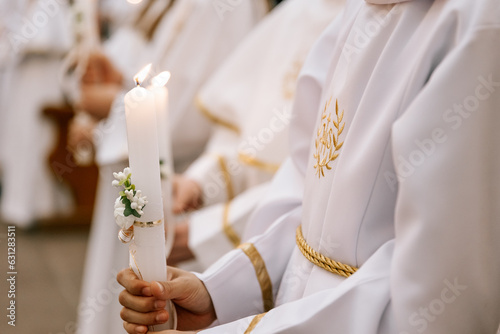 photo of children's hands receiving their first communion in a Catholic church, the priest blesses them