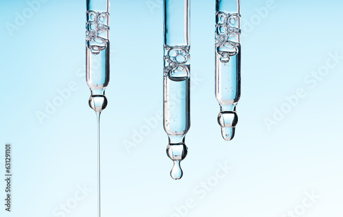 Set pipette serum drop with clear liquid niacinamide, hyaluronic or Aha Bha acids on a blue white isolated background. Textured swatch skincare. Laboratory cosmetics