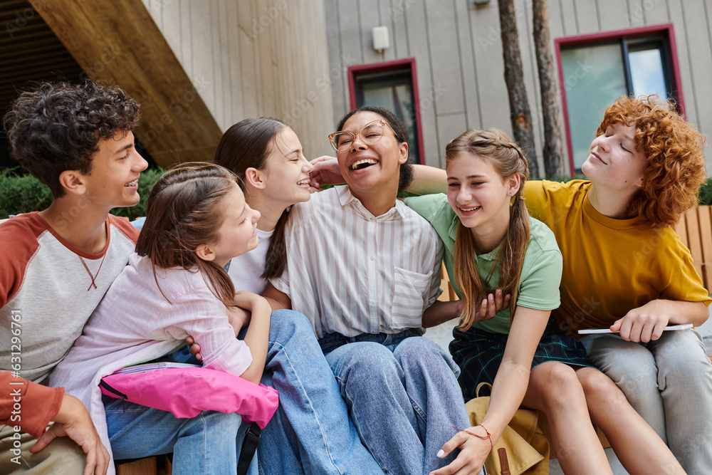 Obraz premium cheerful african american woman hugging with teenage students, diversity, teacher, study, smile