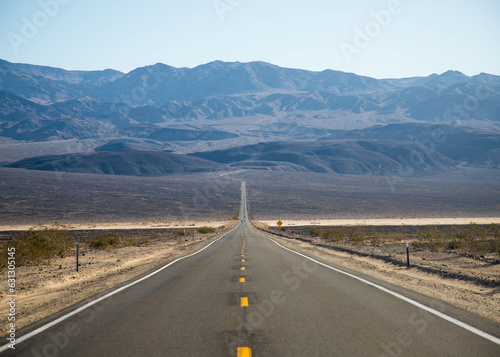 a desert road leads to the mountains of Death Valley National Park, California, USA
