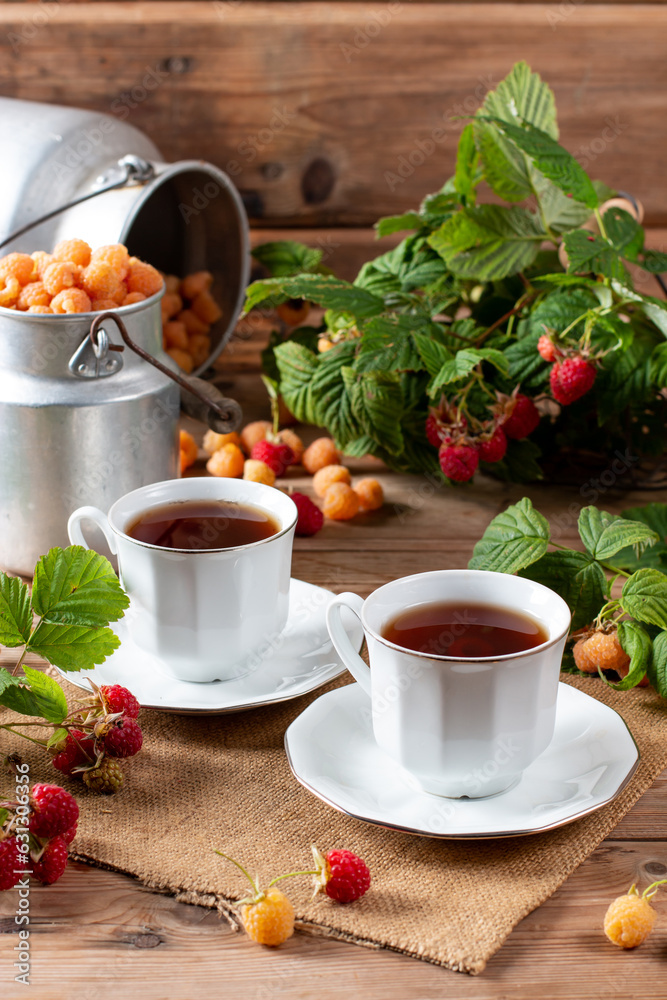 Cup of tasty raspberry tea on wooden table. Useful drink for health. Herbal tea. Traditional medicine. Cup of tasty raspberry tea on wooden table. Useful drink for health. Herbal tea. Traditional medicine.