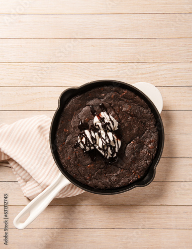 Pan of brownies with vanilla ice cream and hot fudge sauce photo