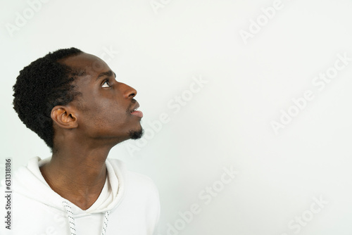 Portrait of a young black man wearing a hat against white background
