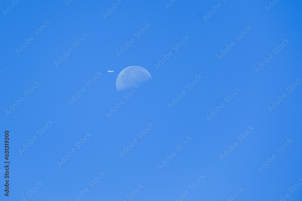Daily Moon with plane in the blue sky Daily Moon with plane in the blue sky
