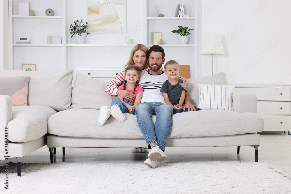 Portrait of happy family with children on sofa at home