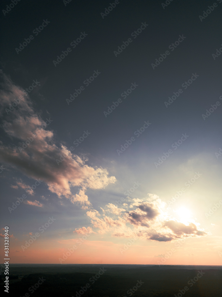 Obraz premium Setting Sun in the Clouds over a Distant Georgia Landscape