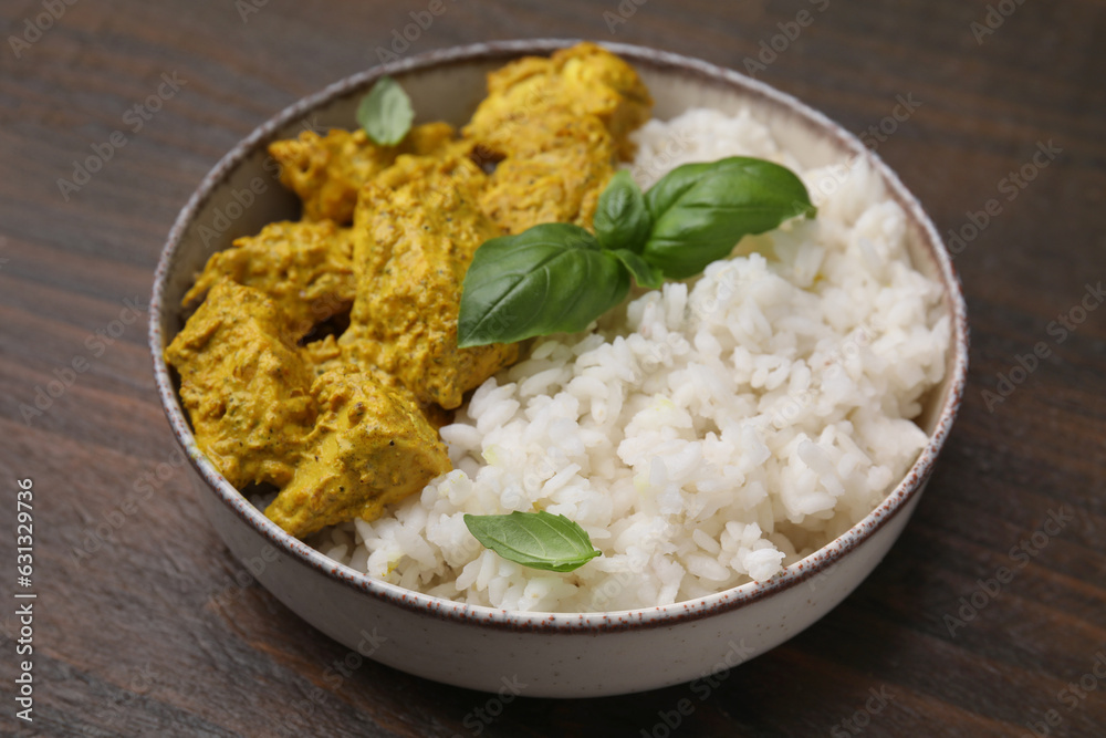 Delicious rice and chicken with curry sauce on wooden table, closeup Delicious rice and chicken with curry sauce on wooden table, closeup