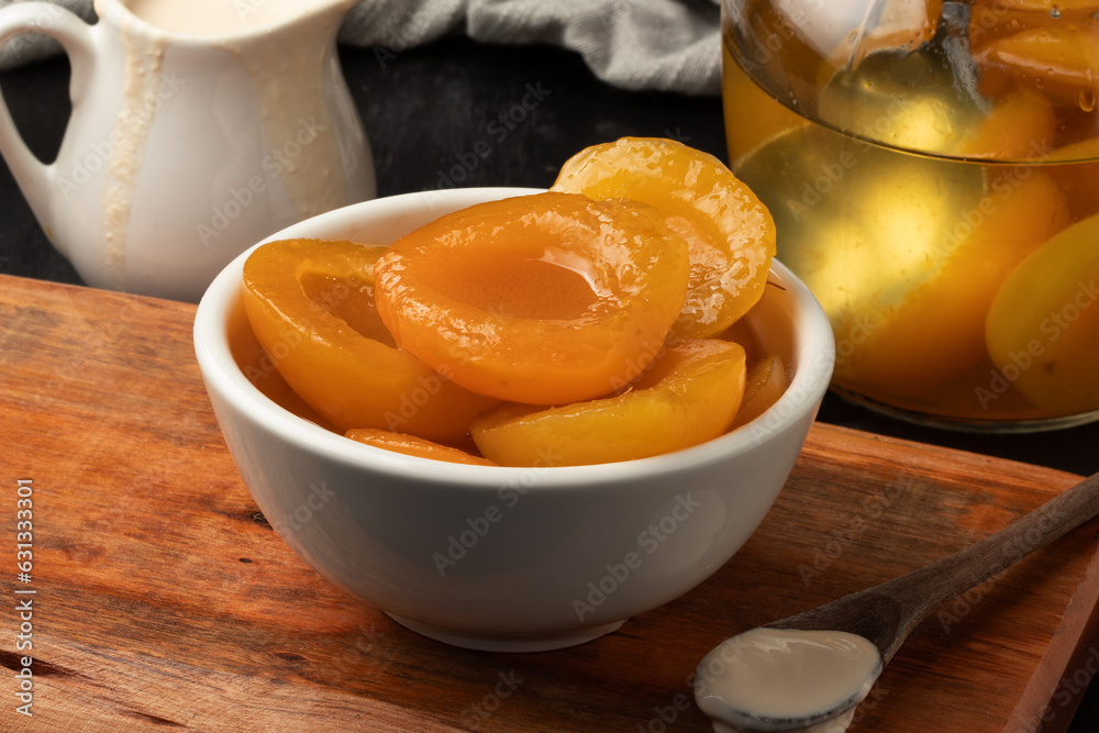 Canned peaches in a bowl served with milk cream. Canned peaches in a bowl served with milk cream.