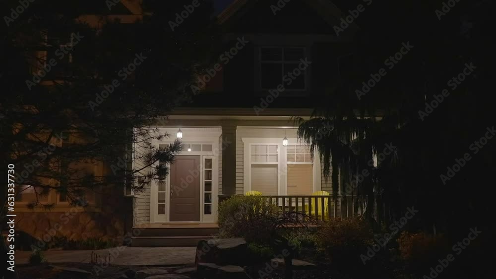 Establishing shot of two story stucco luxury house with garage door, big tree and nice landscape at night in Vancouver, Canada, North America. Night time on Apr 2023. ProRes 422 HQ.